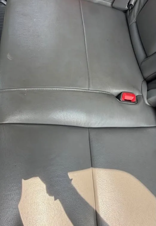 A dark leather rear bench before cleaning and conditioning