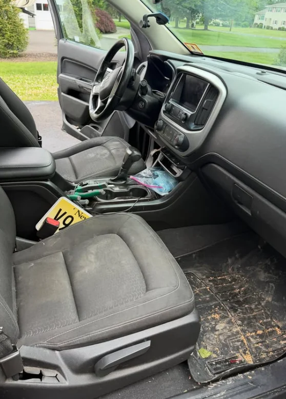A truck interior before detailing, with debris on the seat