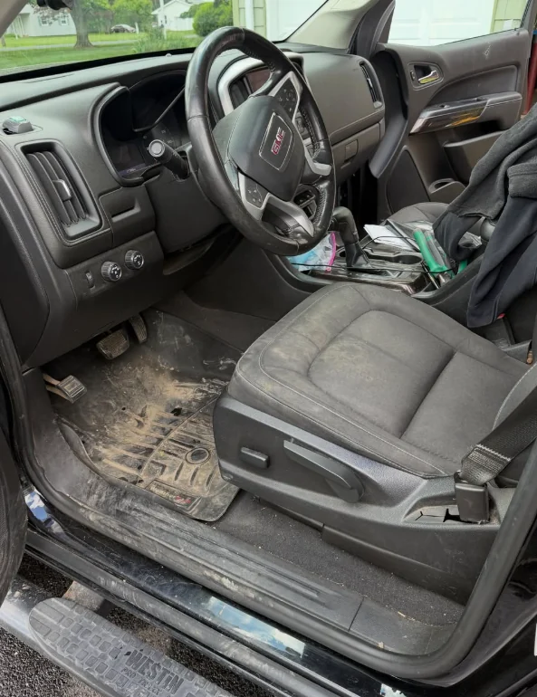 A truck footwell before detailing, with a dirty floor mat