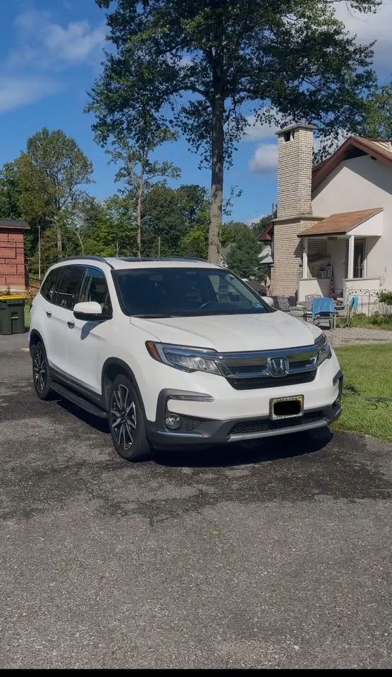 A white Honda Pilot parked outside after an exterior wash