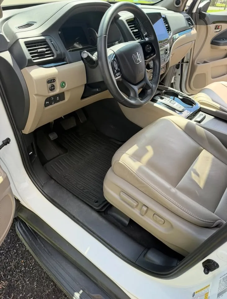 The front interior of a Honda Pilot with tan leather, after detailing