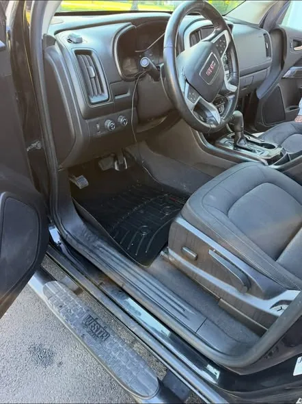 A truck driver's footwell and seat after cleaning, door open